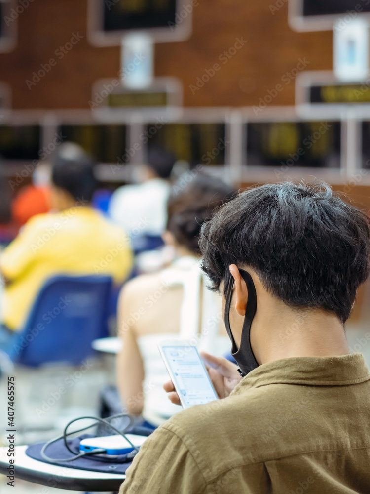 Back view of Asian man wear protective face mask to prevent Coronavirus(COVID-19) sitting on a chair for social distancing in auditorium. Conference concept in coronavirus pandemic.Selective focus. Back view of Asian man wear protective face mask to prevent Coronavirus(COVID-19) sitting on a chair for social distancing in auditorium. Conference concept in coronavirus pandemic.Selective focus.