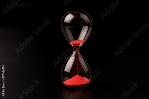 Crystal hourglass on black background as a concept of passing time for business term, urgency and outcome of time.
