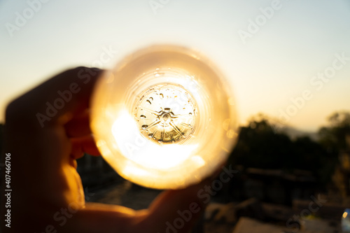 Empty bottle of water with golden sunset through it