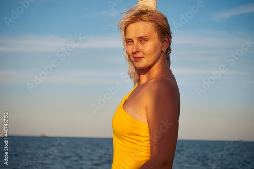 Happy smiling woman stands on the bow of the yacht