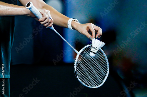 holding a white badminton racket ready to hit the ball photo