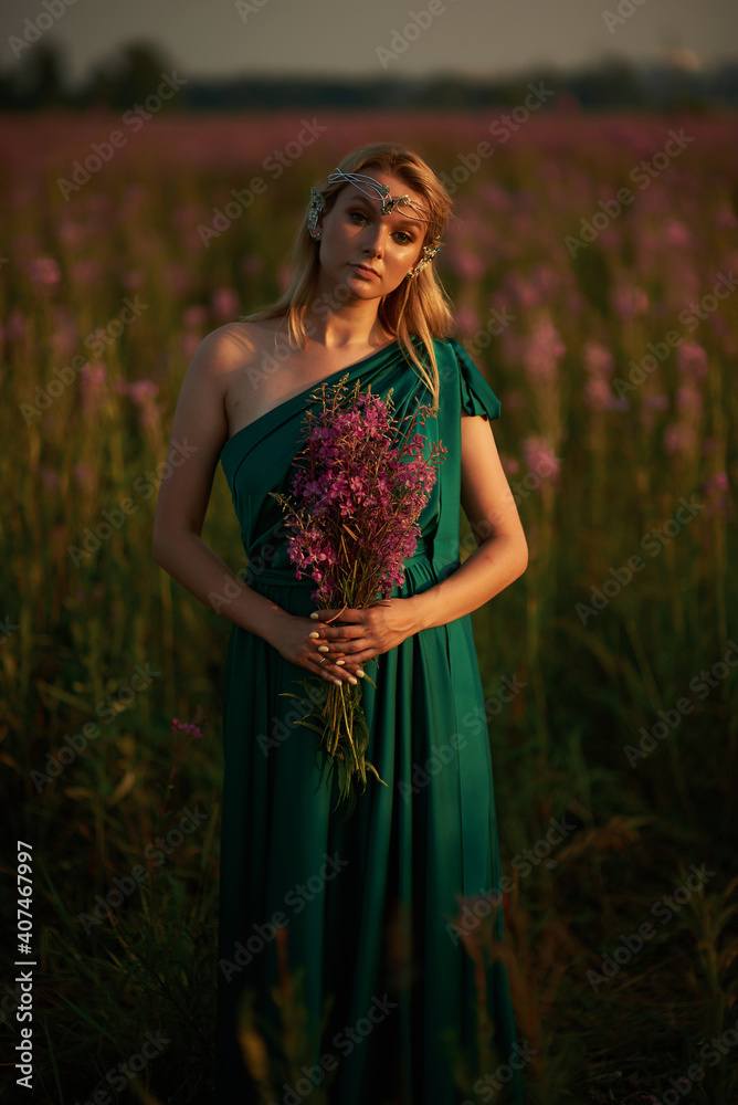 Young beautiful girl with a bouquet of flowers in her hands at sunset. Young beautiful girl with a bouquet of flowers in her hands at sunset.