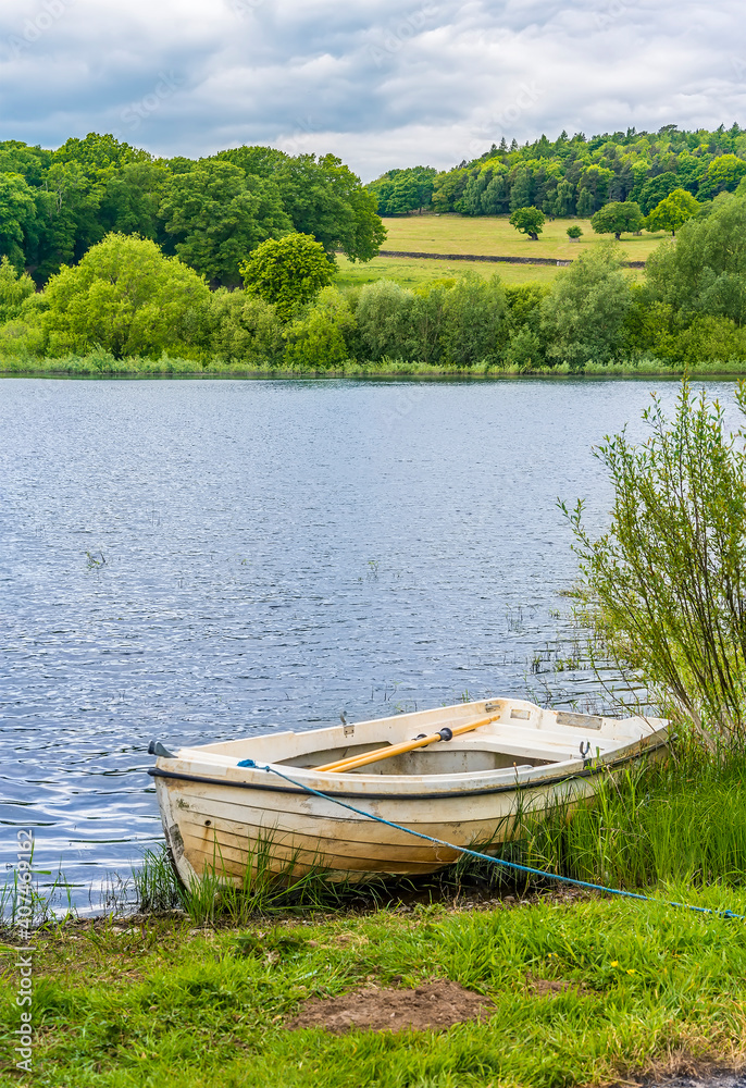 A solitary boat moored on the shore of Cropston Reservoir in Leicestershire in summertime A solitary boat moored on the shore of Cropston Reservoir in Leicestershire in summertime