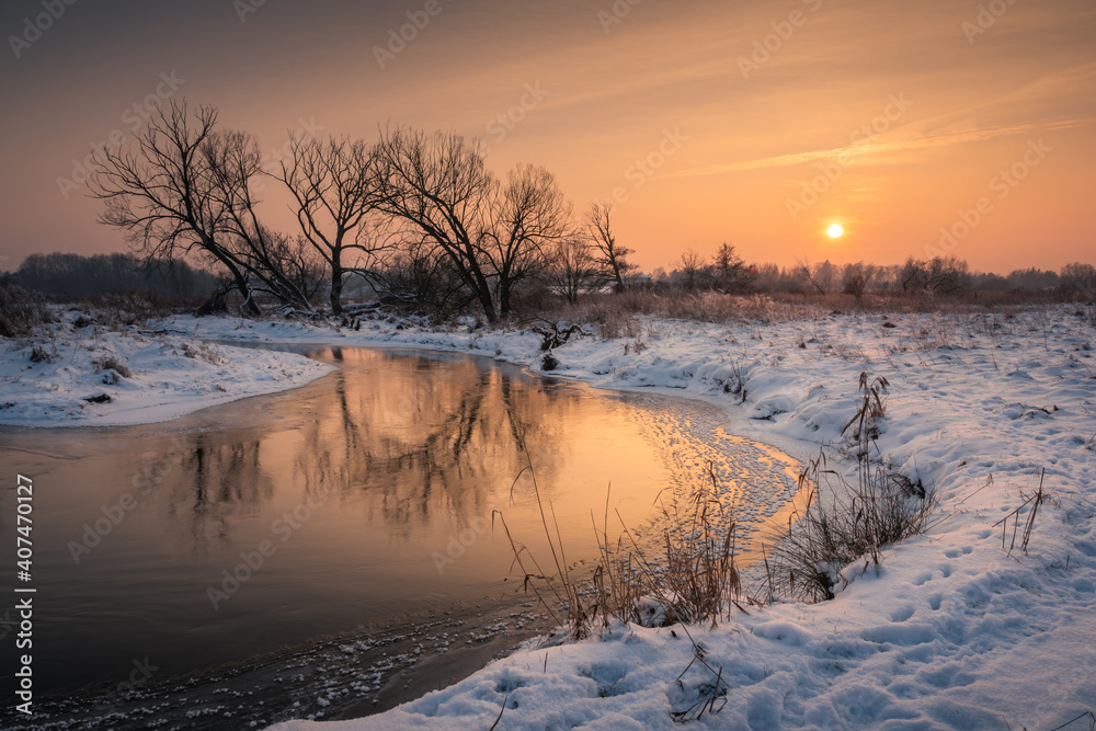 Sunset over the Jeziorka river at winter near Piaseczno, Masovia, Poland