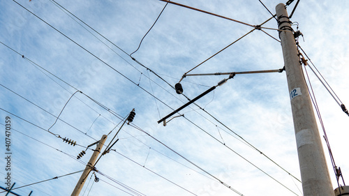 Contact high-voltage power lines on the railway. On the background of the blue sky. photo