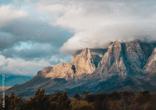 Sunset  shining on franschhoek mountains with clouds rolling over  photo