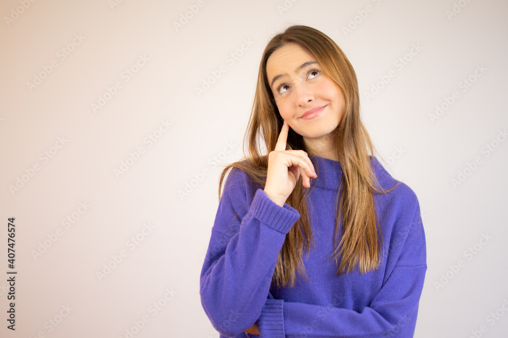 Cute playful young woman smiling and thinking over white background Cute playful young woman smiling and thinking over white background