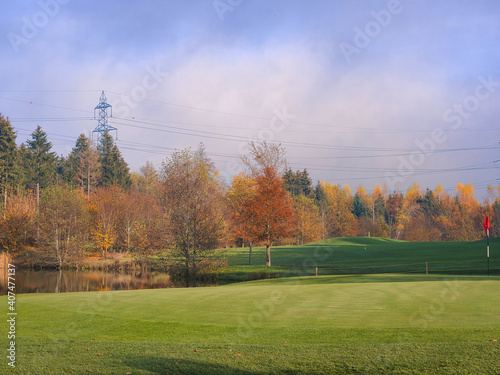 Das Fairway eines Golfplatzes mit Teich und bunten Laubbäumen im Herbst. Gesehen in der Gemeinde Hildisrieden im Bezirk Sursee im Kanton Luzern in der Schweiz