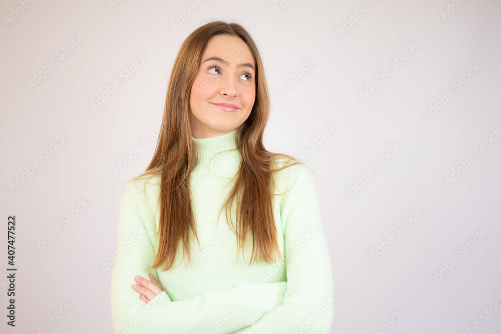 Attractive young girl wearing casual clothes standing isolated over white background, arms folded Attractive young girl wearing casual clothes standing isolated over white background, arms folded