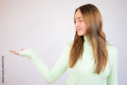 Portrait of a smiling asian woman holding copy space on her palm isolated over white background