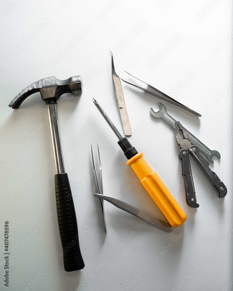 Construction work tools lie on a gray background in a chaotic manner Construction work tools lie on a gray background in a chaotic manner