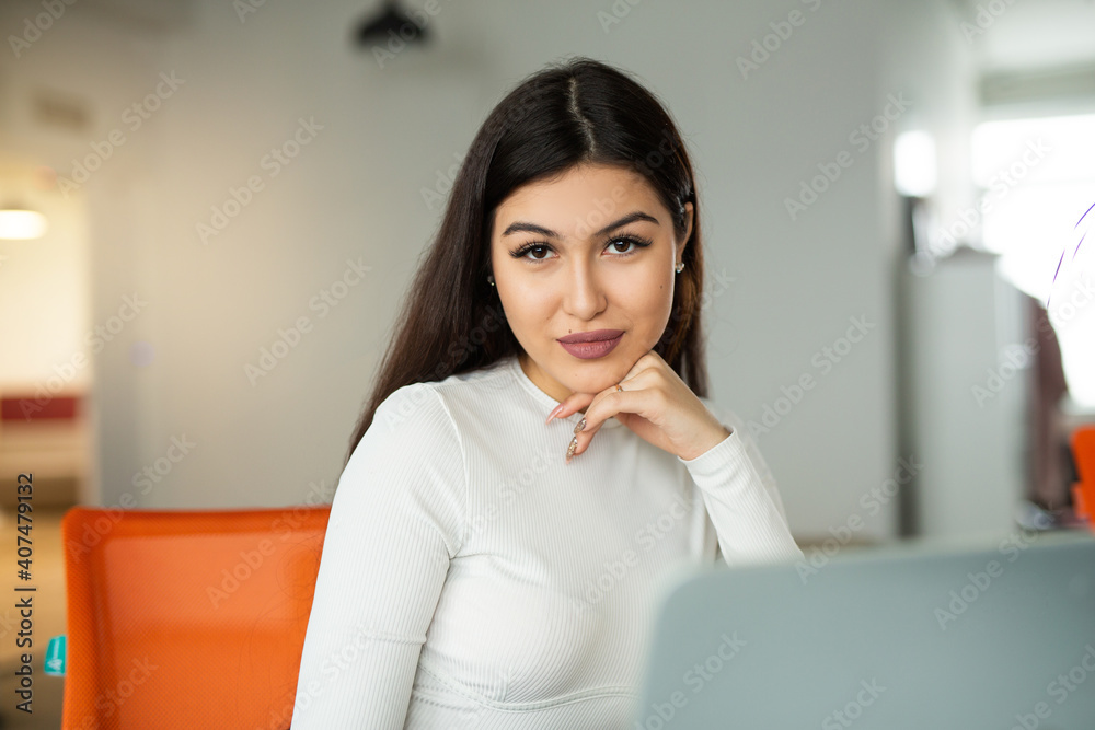 beautiful young woman at the table with laptop in the office beautiful young woman at the table with laptop in the office