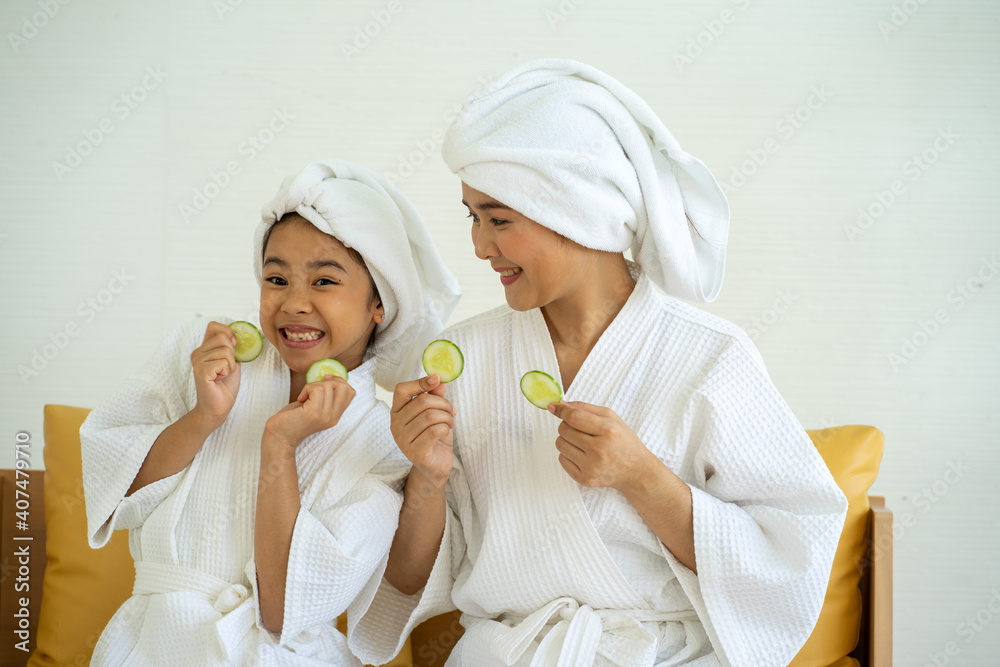 Asian young girl wearing bathrobe with mother with home spa ingredient at home Asian young girl wearing bathrobe with mother with home spa ingredient at home
