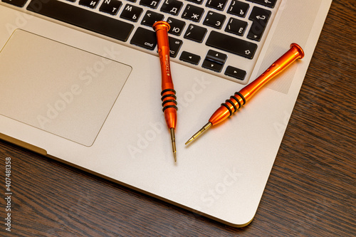 two small screwdrivers lie on a laptop
