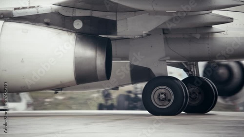 Heat shimmer behind jet engine and landing gear of taxiing airplane. The plane rolls on the runway.