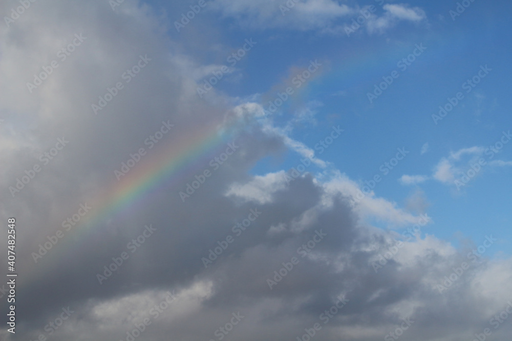 Rainbow from cloudy to blue sky