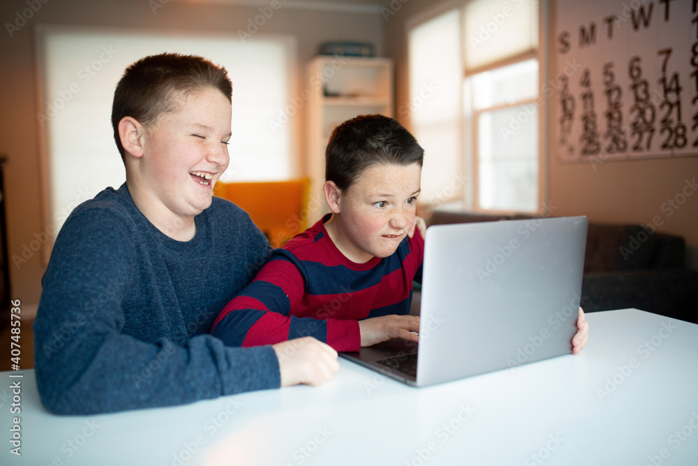 boy looking at a laptop with a worried and confused look boy looking at a laptop with a worried and confused look