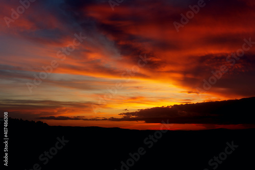 Fiery sunset. Evening sun on the horizon. The clouds are backlit with the bright red light. Pre-sunset twilight. © Rauf