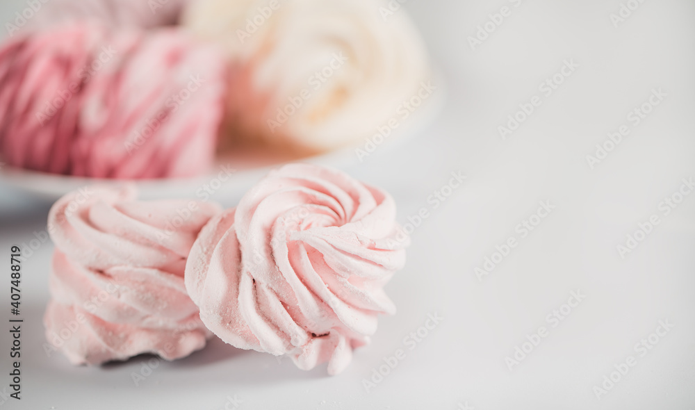 Appetizing multi-colored zephyr on a plate against a white background. Tea drinking concept. Confectionery decoration. Place for text Appetizing multi-colored zephyr on a plate against a white background. Tea drinking concept. Confectionery decoration. Place for text