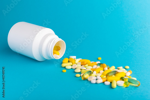 Bottle with colorfu medicine pills on color background. Medical concept. Closeup.