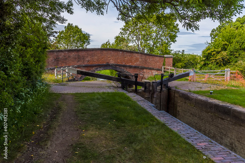 A lock gate and bridge over the Oxford canal at the village of Napton, Warwickshire in summertime