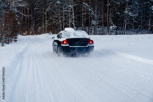 Snow covered car driving on a snowy winter forest road. Runaway from civilization to the nature.