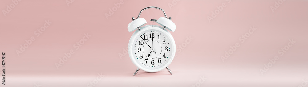 White clock alarm on background pastel shades with copy space banner White clock alarm on background pastel shades with copy space banner