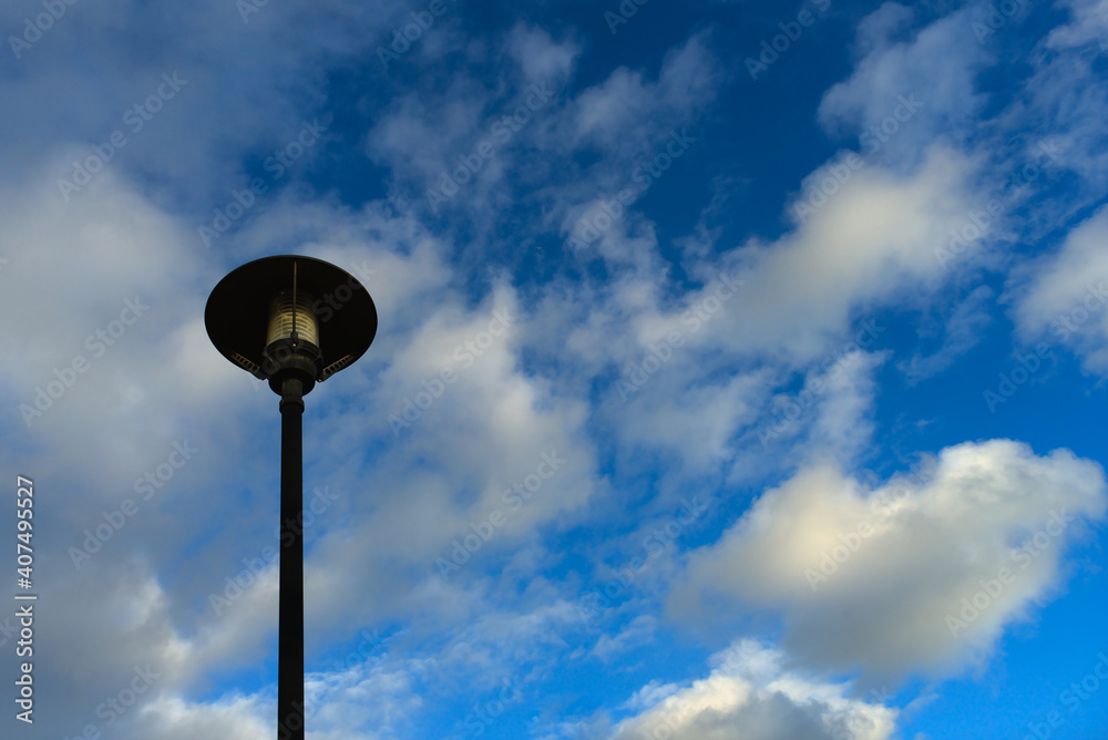 Farola recortándose sobre un cielo azul vestido de nubes. Farola recortándose sobre un cielo azul vestido de nubes.