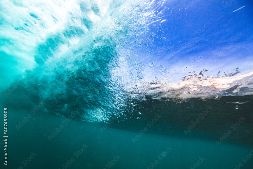 Underwater view from behind breaking wave