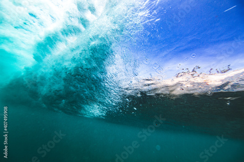 Underwater view from behind breaking wave