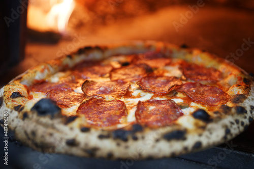 Neapolitan pizza with sausage in a wood-fired oven photo