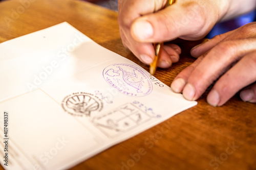 Albergue Hostel Tenant Putting Stamp in Pilgrim Passport Credencial on Camino de Santiago St James Way Pilgrimage Trail photo