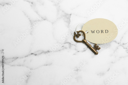 Vintage key with tag on white marble table, top view and space for text. Keyword concept © New Africa