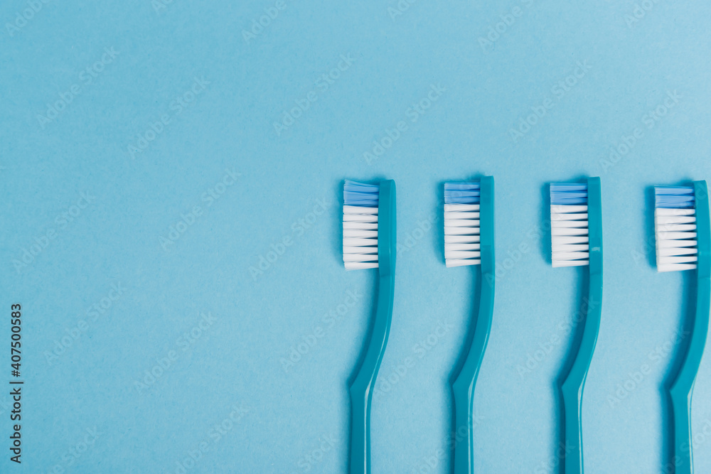 Top view of plastic toothbrushes on blue background Top view of plastic toothbrushes on blue background
