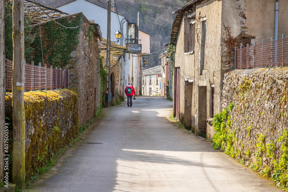 Obraz premium Pilgrim Walking in Town of Triacastela Galicia Spain along the Way of St James Camino de Santiago Pilgrimage Trail