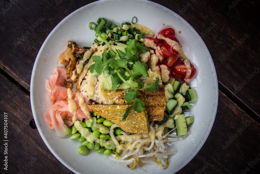 Nourish Bowl with tempeh, brown rice, cucumber, edamame beans, tomato, bean sprouts, coriander in white dish Nourish Bowl with tempeh, brown rice, cucumber, edamame beans, tomato, bean sprouts, coriander in white dish