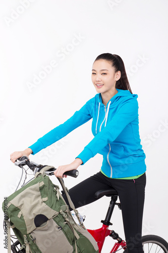 Young woman with backpack,taking a bike