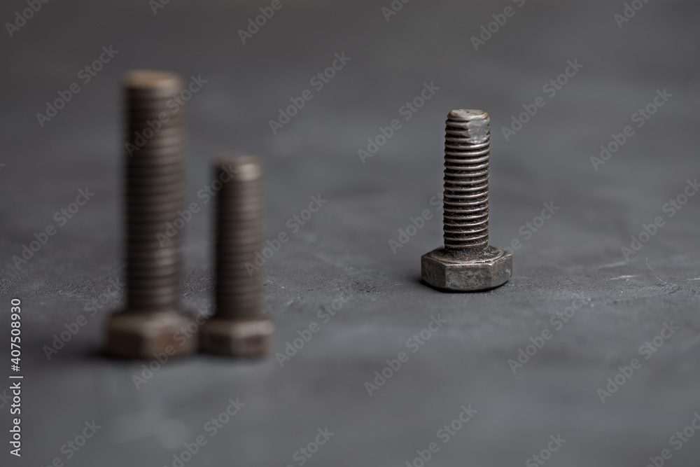 Fototapeta premium The three bolts represent three people. Items on a dark background.