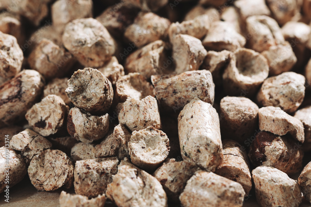 A bunch of wood pellets for heating industrial boilers with solid fuel boilers. Background vertical macro image of biomass pellets close-up. Eco-friendly and low cost fuel concept A bunch of wood pellets for heating industrial boilers with solid fuel boilers. Background vertical macro image of biomass pellets close-up. Eco-friendly and low cost fuel concept