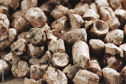 A bunch of wood pellets for heating industrial boilers with solid fuel boilers. Background vertical macro image of biomass pellets close-up. Eco-friendly and low cost fuel concept