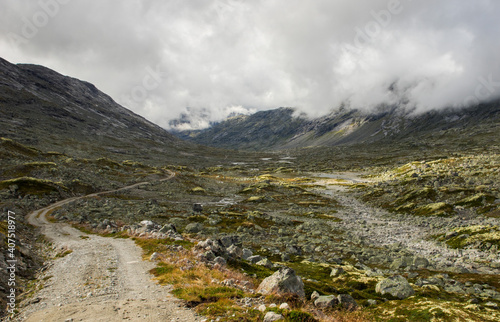 Gravel road in norwegian mountains towards Middalen valley