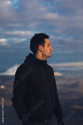 Young hiker at the top of a snowy mountain on winter.