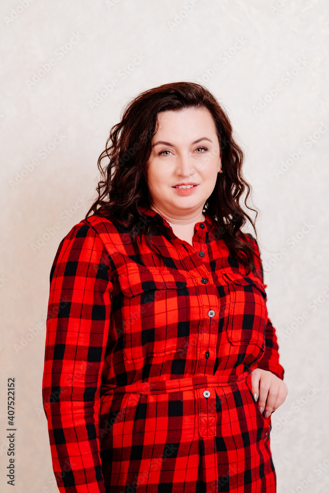 attractive woman in a red checkered dress on a white background. attractive woman in a red checkered dress on a white background.