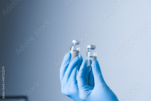 2 doses of coronavirus vaccine. Close-up covid-19 Vaccination. Woman in blue medical gloves holding medication.
