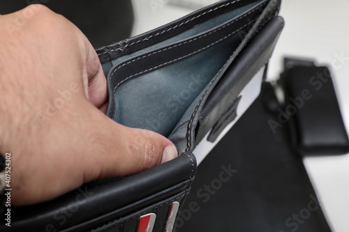 A man opens the wallet to pay for his purchase.