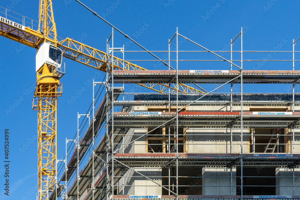construction site with crane, building with scaffolding at the outside facade