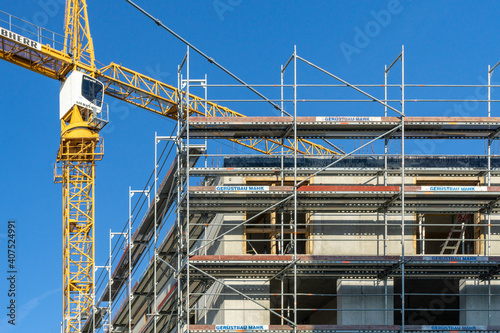 construction site with crane, building with scaffolding at the outside facade