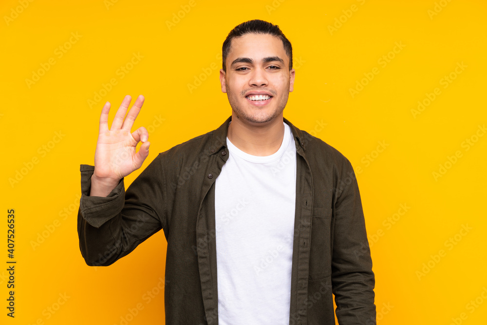 Asian handsome man isolated on yellow background having doubts Asian handsome man isolated on yellow background having doubts