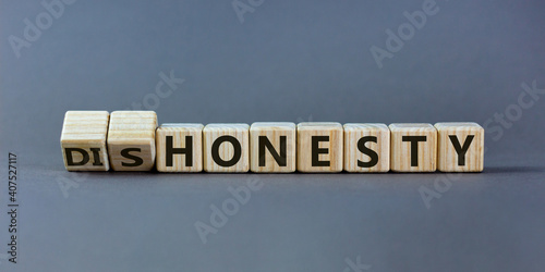 Honesty or dishonesty symbol. Turned cube and changed the word 'dishonesty' to 'honesty'. Beautiful grey background. Business and honesty or dishonesty concept. Copy space.