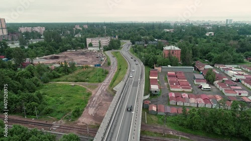 Two police cars drive along the overpass. Aerial view.